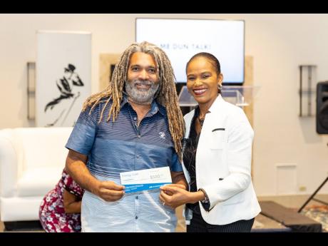 Credit: Contributed Joseph Heron, chairman of The Affirming Fathers Project cheerfully collects his prize for participating in the Johnnie Walker sponsored Men-Tell Workshop from Ruthlyn Johnson, JPS Customer Service Area Manager - East.