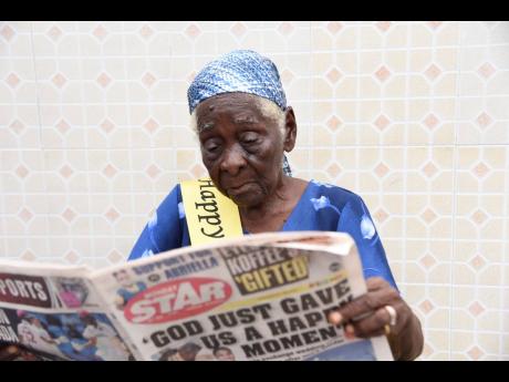 Centenarian Viola Brown reads a copy of THE STAR without glasses.