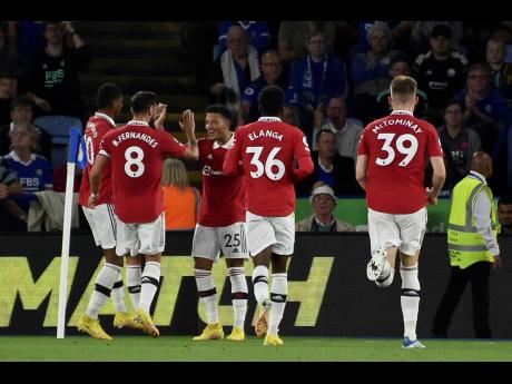 Manchester United’s Jadon Sancho (centre) celebrates with teammates after scoring against Leicester City during the English Premier League match  at King Power stadium in Leicester, England yesterday.