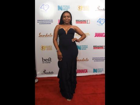 Attorney-at-law, Paige Gordon, strikes a pose in a plunging off-the-shoulder gown. 