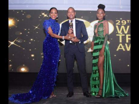 Christopher Elliott (centre), general manager, Sandals Montego Bay, accepts the award for Jamaica’s Leading Resort 2022, flanked by the lovely Dr Terri-Karelle Reid (left) and Therry-Lee Reid. 