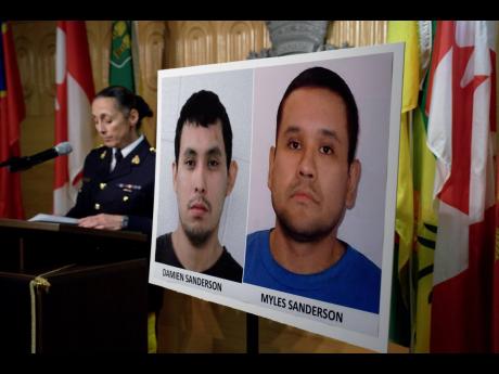 Assistant Commissioner Rhonda Blackmore speaks next to images of stabbing suspects Damien Sanderson and Myles Sanderson during a press conference at the Royal Canadian Mounted Police F Division headquarters in Regina, Saskatchewan, on Sunday. Police said t