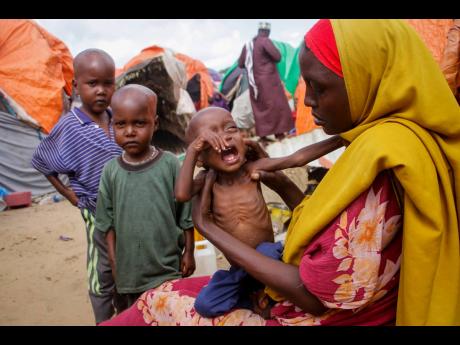 Maryan Madey, who fled the drought-stricken Lower Shabelle region, holds her malnourished daughter Deka Ali, one, at a camp for the displaced on the outskirts of Mogadishu, Somalia on Saturday. Millions of people in the Horn of Africa region are going hung