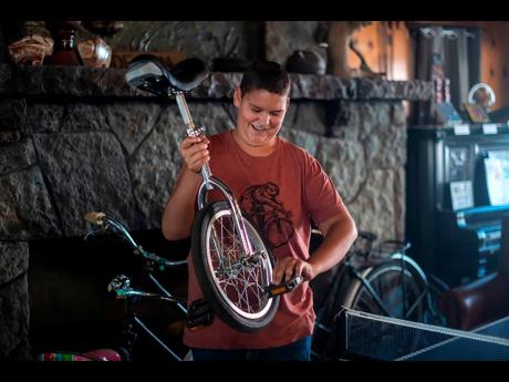 Credit: AP Daniel Giffin holds his unicycle at the Buffalo Lodge Bicycle Resort in Colorado Springs, Colo, on Wednesday, Aug 10, 2022. Giffin, 15, was diagnosed with brain cancer at age 11 and has since discovered a passion for e-biking. Prior to his diagnosis, Giffi