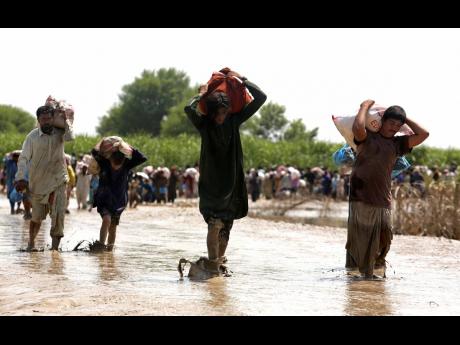 Credit: Fareed Khan Victims of unprecedented flooding from monsoon rains receive relief aid organised by the Edhi Foundation, in the Ghotki District of Sindh, Pakistan yesterday.