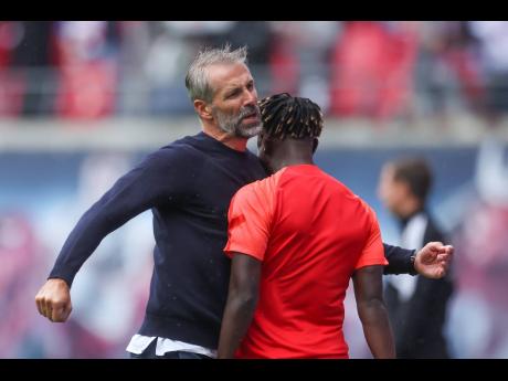 Leipzig coach Marco Rose (left) and Amadou Haidara celebrate during a German Bundesliga soccer match against Borussia Dortmund in Leipzig on Saturday.