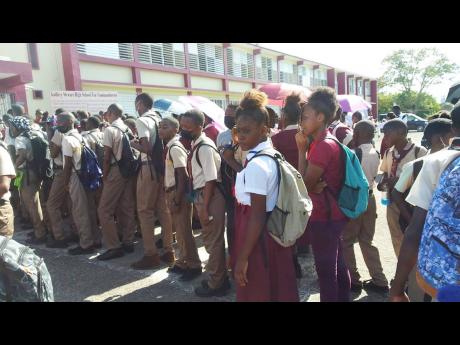Credit: Christopher Thomas Students of Godfrey Stewart High School in Savanna-la-mar, Westmoreland, stand outside the institution’s front entrance after reportedly being denied entry because of dress code violations.