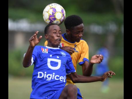 Credit: Ricardo Makyn
Norman Manley High School’s Raheim Wickham heads the ball while Tarrant High School’s Ricardo Francis pushes in his back. during the Inter-Secondary Schools’ Sports Association (ISSA)/Digicel Manning Cup football game at Maxfield Park yesterday. Nor