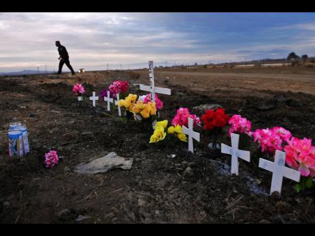 Credit: AP AP
In this January 2, 2021 photo, a row of crosses form a memorial along Highway 33 as police officers survey the scene a day after a crash killed nine people south of Coalinga, California.