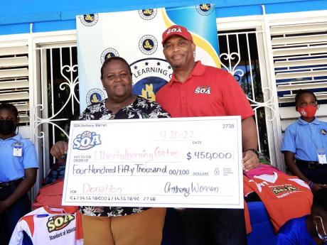 Credit: Carl Gilchrist Rosemarie Brent-Harris, principal of Liberty Learning Centre, accepts a cheque from Anthony Warren (right), CEO of Standard of Athletics, on Tuesday to assist with the building of a multipurpose court at the St Mary school.