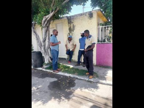 Credit: Photo by Andre Williams St Catherine South Eastern Member of Parliament Robert Miller speaks with National Water Commission crewmen who were in Falmouth East, Waterford, Thursday. Clogged manholes have worsened sewerage woes in the community.