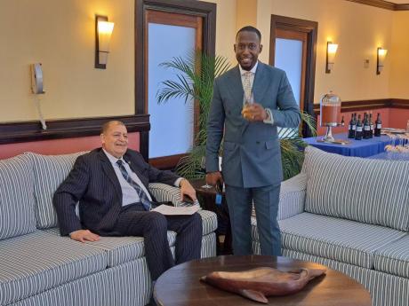 Transport and Mining Minister Audley Shaw (seated) sharing a light moment with Jason Thomas, an investor representing technology developer Rydeum Caribbean, during the launch of Rydeum’s new DoGetGo transportation mobile app at the Half Moon Resort in Ro