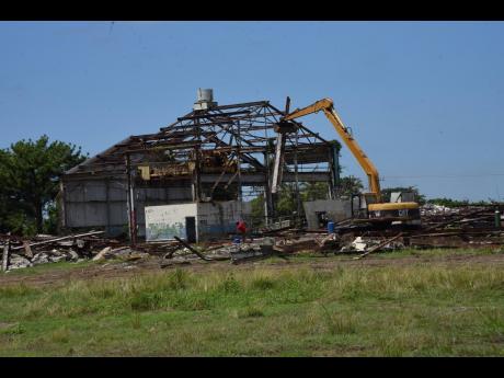 Credit: Ian Allen An equipment demolishing a section of the Goodyear tyre factory ruins in St Thomas on September 8. The Morant Bay Urban Centre is to be established on that property.