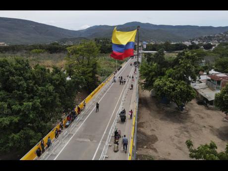 Pedestrians use the Simon Bolivar International Bridge to cross between San Antonio, Venezuela, and Cucuta, Colombia, on Sunday, September 25. The Simon Bolívar and Francisco de Paula Santander international bridges will once again connect legal trade bet