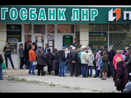 People line up to an office of Luhansk People’s Republic state bank, a day after voting in four Moscow-held regions of Ukraine on referendums to become part of Russia, in Luhansk, Luhansk People’s Republic controlled by Russia-backed separatists, easte