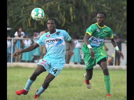 Denbigh’s Shamar Watson (left) watches the ball closely as Old Harbour’s Orlando Smith presses during their ISSA/Digicel  daCosta Cup Zone M encounter at Denbigh High yesterday. Old Harbour won 3-2.