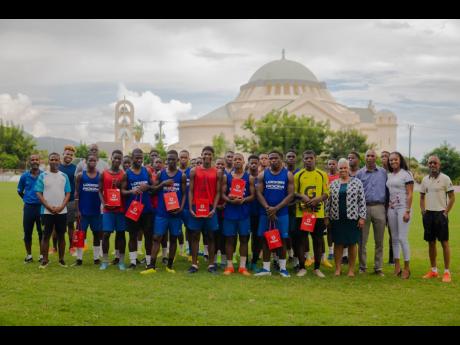 
St George’s College Manning Cup team members stopped training to pose for a picture and show off their Digicel-branded packages with their new smartphones and replacement SIMs. Pictured among them are team officials from right: Head Coach Neville Bell, 