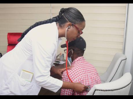 Cardiologist Dr Claudine Lewis, proprietor of Heart Smart Centre at the GWest Medical and Surgery Centre examines a patient during a heart-health fair.