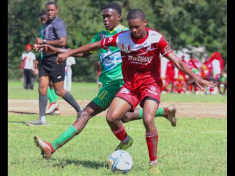 Glenmuir High’s Nuemonie Blackwood (right) shields  the ball from Mario Miller of Old Harbour High during their ISSA/Digicel daCosta Cup Group M encounter at Port Esquivel yesterday. Glenmuir won 2-0.