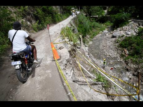 A motorist rides past a breakaway on the Mavis Bank main road at Craig Hill, St Andrew, on Sunday, October 2.  