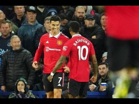 Manchester United’s Cristiano Ronaldo (left) celebrates with teammate Marcus Rashford after scoring his side’s second goal during the English Premier League match against Everton at Goodison Park, in Liverpool, England, yesterday.
