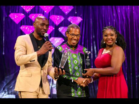 From left: Kevin Downswell and Pastor Courtney Morrison accept awards on behalf of gospel singer Chozenn, presented by Sara-Ann Edwards-Miller. 