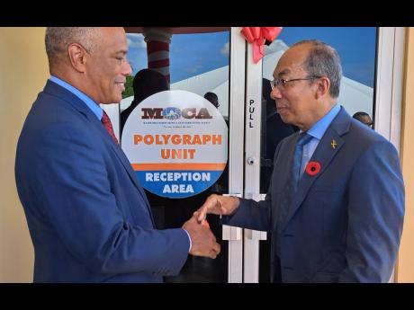 Col Desmond Edwards (left), director general of the Major Organised Crime and Anti-Corruption Agency, greets National Security Minister Dr Horace Chang at the launch of MOCA polygraph examiner’s training course at the National Police College in Twickenha