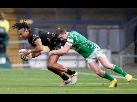 Jamaica’s Alex Young (left) is tackled by Ireland’s Ed Chamberlain during the Rugby League World Cup Group C match between Ireland and Jamaica at Headingley Stadium, Leeds, England yesterday.