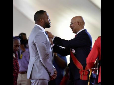 Credit: Kenyon Hemans Jeffery ‘Agent Sasco’ Campbell (left), is conferred with the Order of Distinction in the rank of officer by Governor General Sir Patrick Allen.