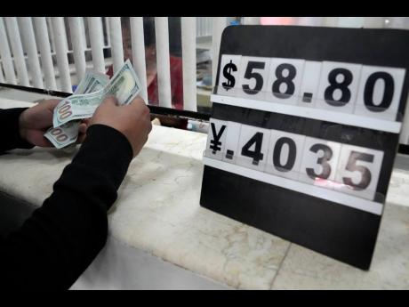 A man changes his US dollars to Philippine pesos at a money changer in Manila, Philippines, on October 11, 2022.