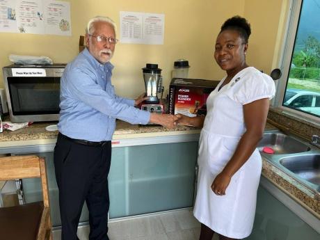  Tracey-Thompson McLean, matron of the Manchester Infirmary, accepts a commercial blender valued at $60,000 from Horace Bogues, managing director of Bogues Brothers Industries Limited. McLean expressed appreciation for the donation, which, she said, will g