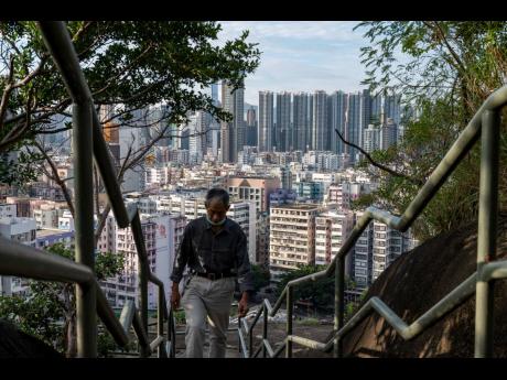 AP Photos 
A man climbs the steps near residential housing in Hong Kong on Wednesday, October 19.
