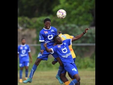 Norman Manley High School players (from left) Dominique Lowe and Dominique Brown endure a clash of heads, going for the same ball during an ISSA/Digicel Manning Cup game.