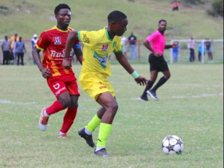 Credit: Lennox Aldred Photo Vere Technical's Malcolm Lennon (right) dribbles away from Cornwall College's Giovanne Bruce during their ISSA daCosta Cup game at Glenmuir High School today.