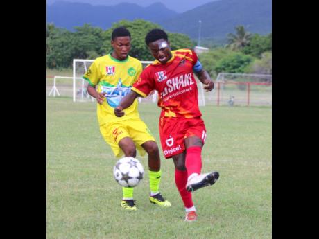 
Cornwall College’s Giovanne Bruce plays a ball down the line as Vere Technical’s Rusheim Ryan rushes in during their ISSA daCosta Cup first-leg second-round encounter at Glenmuir High School yesterday
