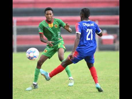 Credit: Ricardo Makyn Humble Lion’s Shamari Dallas (left) battles for the ball with Dunbeholden’s Shakeen Powell during yesterday’s Jamaica Premier League match at the Anthony Spaulding Sports Complex. The game ended in a 0-0 draw.