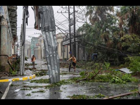 Fallen electricity lines, metal and tree branches litter a street after Hurricane Ian hit Pinar del Rio, Cuba, on September 27.  