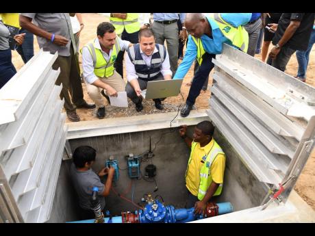 From top left: Alvaro Ramalho, country manager of MIYA Water; Senator Matthew Samuda, de facto minister of water; and Garwaine Johnson, regional manager of the National Water Commission (NWC), have discussions with Andre Edwards (right foreground), mainten