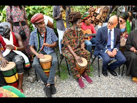 
Prince Ermias (right) enjoys the drumming of the Binghistra Movement during his tour of Culture Yard, in Trench Town.  