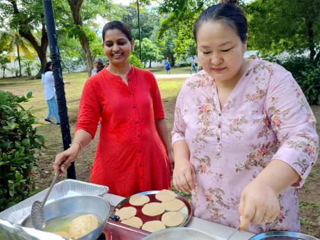 Head of the Mathematics Department at the University of the West Indies (UWI), Mona, Nagarani Ponakala, and Zingcharwon Runsung, wife of the Indian High Commissioner to Jamaica, prepare Puri, which is a fried Indian bread, for breakfast following the Unity