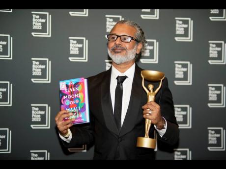 Credit: AP Author Shehan Karunatilaka holds the Booker Prize during a photo call after the announcement of his victory, at the Roundhouse in London.
