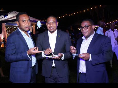 Credit: Oneil Grant Photography Floyd Green (centre), minister without portfolio in the Office of the Prime Minister, is seen enjoying the Pork Palooza festivities. He is joined in a photo op by Bobby Honeyghan, general manager of the Urban Development Corporation Jamaica (left) and Chri