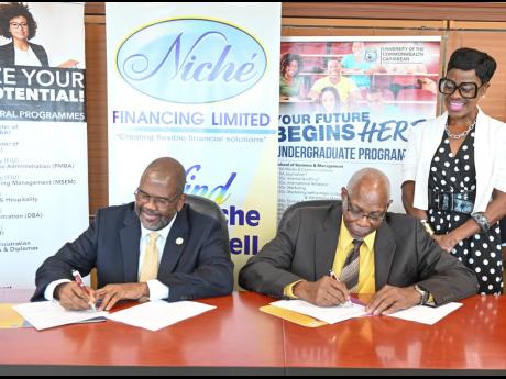 Niche Financing managing director Denniston Brown (left) and University of the Caribbean president Dr Haldane Davies sign an agreement on Thursday November 3, 2022 for the Niche Education Loan partnership to lend up to $4 million to students studying at th
