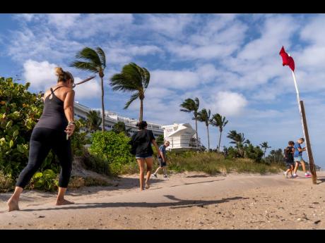 A red flag, signalling high surf and strong currents, flies in strong wind on the beach in Palm Beach, Florida, on Tuesday, November 8.