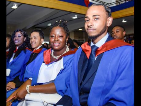 Credit: Nicholas Nunes/Photographer From right: School of Computing and Information Technology graduates Alexander McIntosh, Celine Lobban, Michael Levy and Barri-Ann Lawrence pose for a photo during their graduation ceremony at the National Arena on Friday.