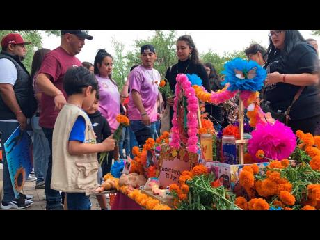 
Family and community members lay flowers on a Day of the Dead altar honouring the lives of the Uvalde school shooting victims on November 1, 2022, in Austin, Texas. 