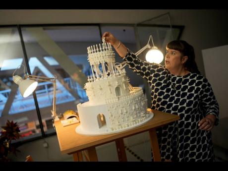 Joana Vasconcelos places a human figure on the top tier of a model of her 12 metres high and 15 metres wide ceramic wedding cake.