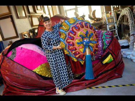Portuguese artist Joana Vasconcelos poses for a picture while pulling one of her works out of a huge bag at her studio in Lisbon.