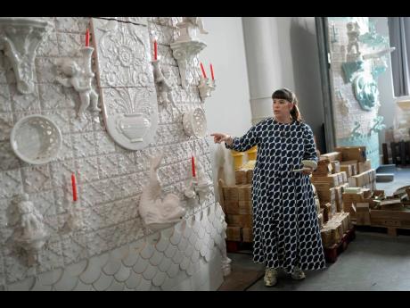 
Joana Vasconcelos points at a full size work model of a section of her 12 metres high and 15 metres wide ceramic wedding cake, at her studio in Lisbon.