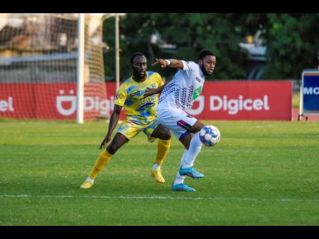 Credit: Nicholas Nunes/Photographer Rohane Brown (right) of Chapelton Maroons turns away from Damion Binns of Waterhouse during last night’s Jamaica Premier League match at the Stadium East field. The Maroons won 1-0 with Brown scoring in the 20th minute.
